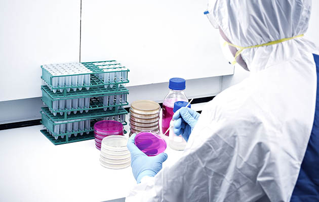 A medical student in protective gear does research in a lab