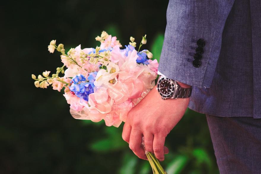 Man with red hand holds flowers