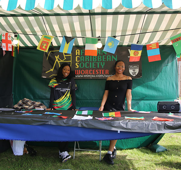Two students are standing at the Afro Carribean society stall at the Welcome fair