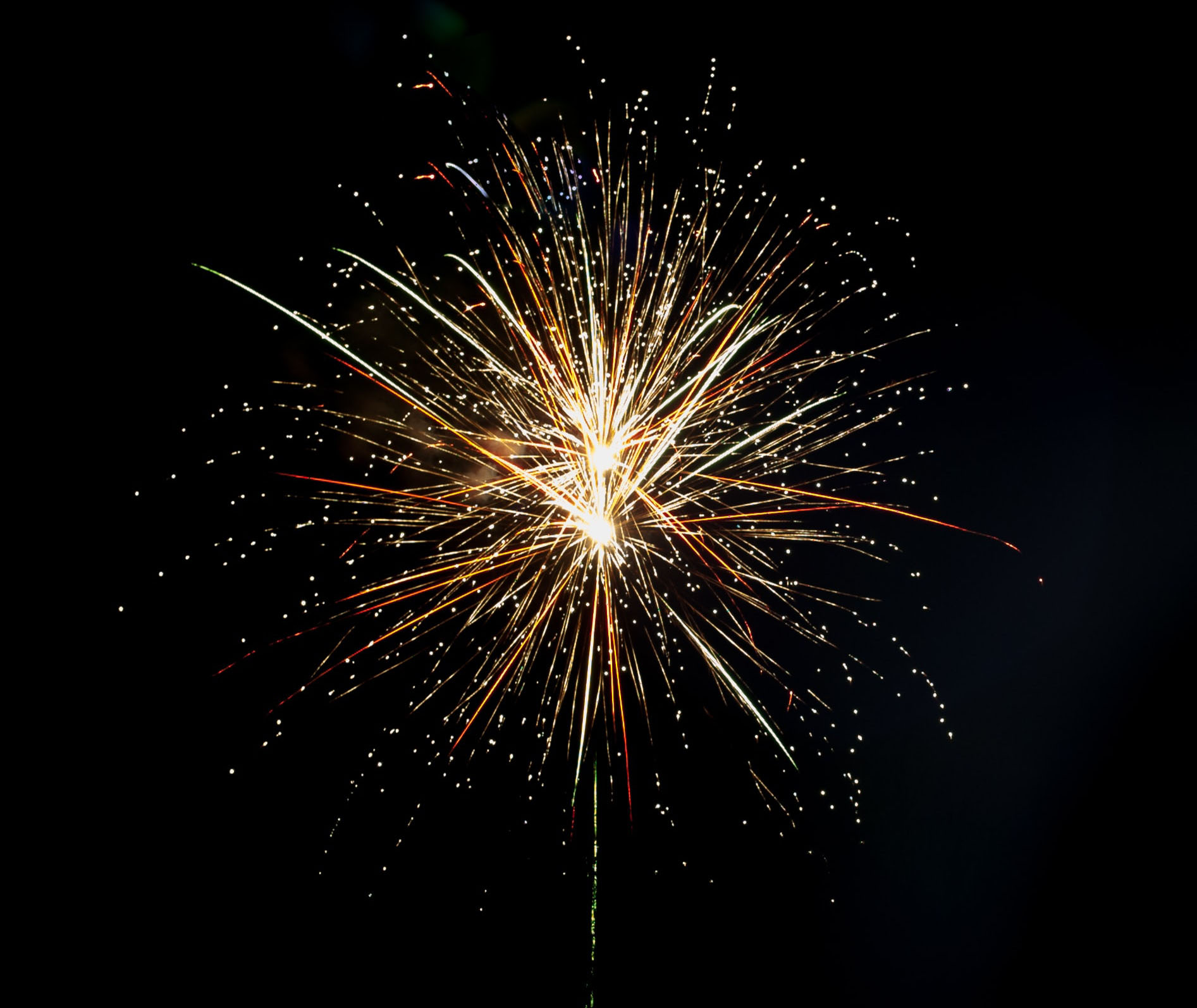 A yellow fire work is exploding into a dark sky