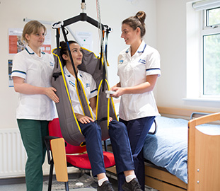 Three nurses one of which is in a cradle