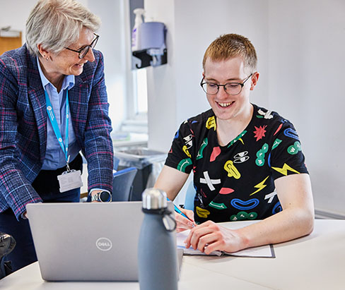 Lecturer talking one-to-one with a student in class
