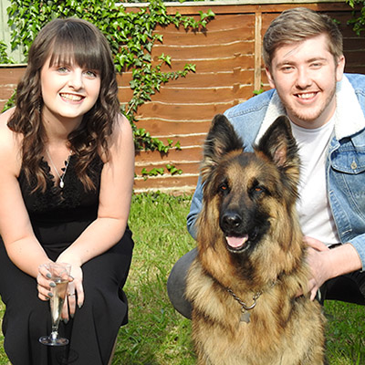 Young couple with a German shepherd in the foreground