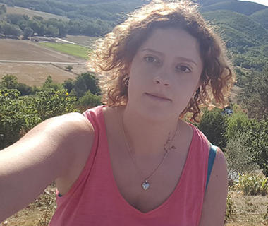 Woman in a pink top with hills in the background