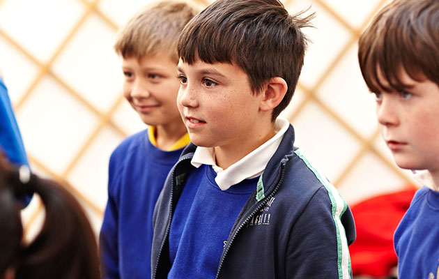 Three male schoolchildren in blue uniform