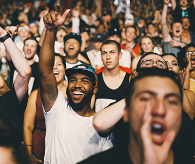 a group of smiling men are at a sporting event