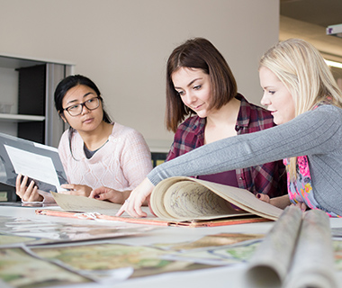 Three female students reviewing documents