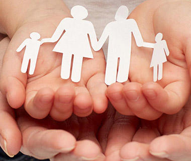 Hands holding a paper cut out family