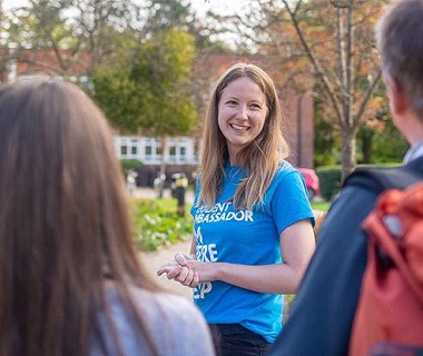 girl in a blue t-shirt glancing sideways and smiling