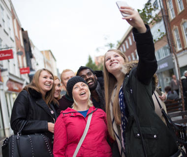 students in the high street taking a selfie