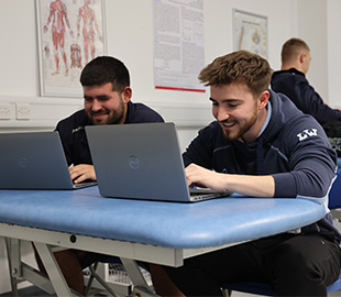 two students taking notes