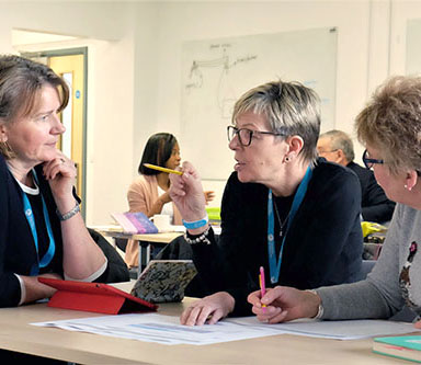 a discussion between three women at a desk