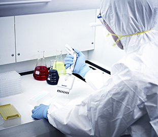 student in white protective clothing at a desk